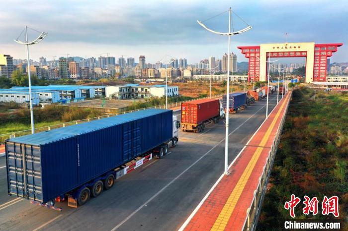 物流貨車在廣西東興二橋上排隊進(jìn)關(guān)?！≈苘?攝
