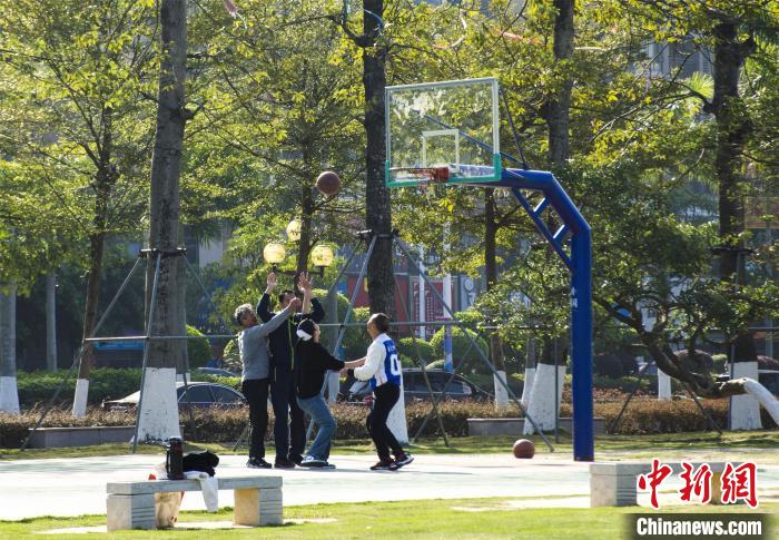 圖為市民、游客在防城港市公園廣場打籃球?！〉岳顝?攝